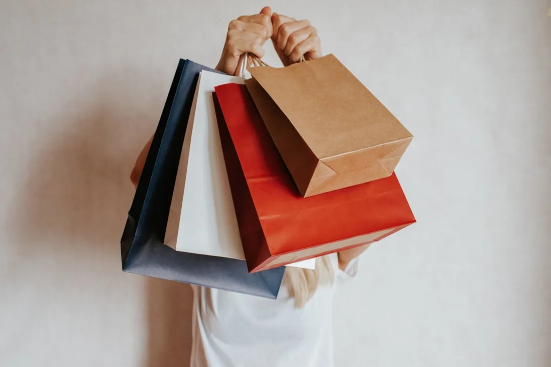 Imagem ilustrativa: pessoa segurando sacolas de compras